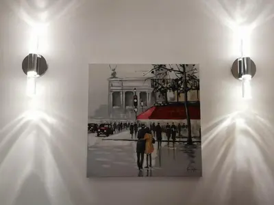 a painting hanging on a wall with two lights at 5 min to sea and Palais des Festivals in Cannes