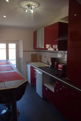 a kitchen with red cabinets and a counter top at 5 min to sea and Palais des Festivals in Cannes