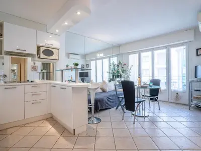 a kitchen and living room with a table and a couch at Apartment Le Cheverny by Interhome in Cannes