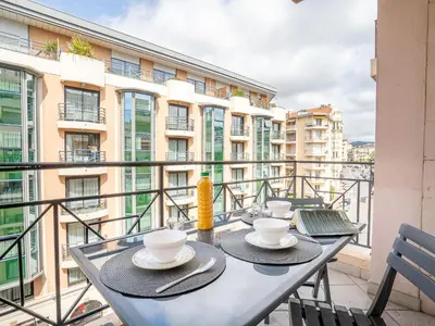 a table with cups and saucers on a balcony at Apartment Le Cheverny by Interhome in Cannes