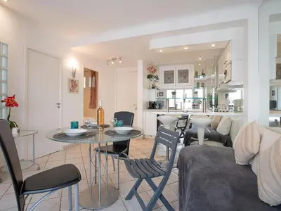 a kitchen and living room with a table and a couch at Apartment Le Cheverny by Interhome in Cannes
