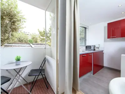 a kitchen with red cabinets and a table and a window at Apartment Le Corsaire-5 by Interhome in Cannes