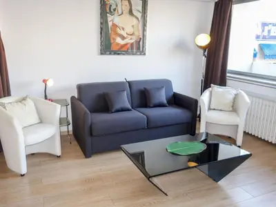 a living room with a blue couch and two chairs at Apartment Le Corsaire-5 by Interhome in Cannes