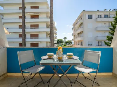a table with two chairs and cups on a balcony at Apartment Le Marlyne 1 by Interhome in Cannes