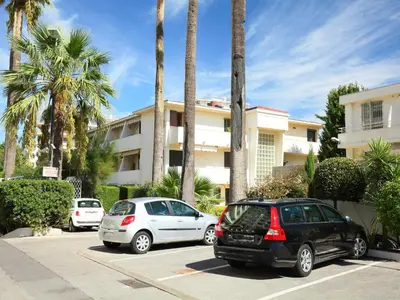 two cars parked in a parking lot in front of a building at Apartment Le Marlyne 1 by Interhome in Cannes