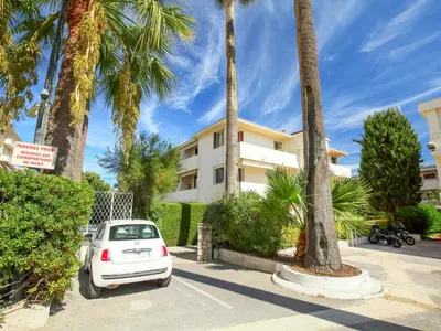a white car parked in front of a building with palm trees at Apartment Le Marlyne 1 by Interhome in Cannes