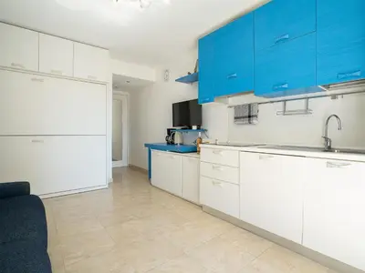 a kitchen with white counters and blue cabinets at Apartment Le Marlyne 1 by Interhome in Cannes