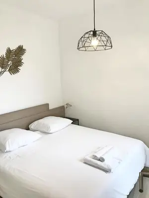 a bedroom with a white bed and a light fixture at Loft de standing Cannes in Cannes