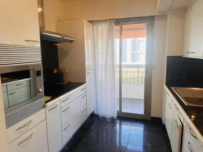 a kitchen with white cabinets and a large window at One bedroom apartment in the center of Cannes, next to the Carlton, a few meters from the Croisette - 367 in Cannes