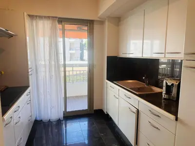 a kitchen with white cabinets and a sink and a window at One bedroom apartment in the center of Cannes, next to the Carlton, a few meters from the Croisette - 367 in Cannes