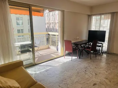a living room with a table and chairs and a balcony at One bedroom apartment in the center of Cannes, next to the Carlton, a few meters from the Croisette - 367 in Cannes