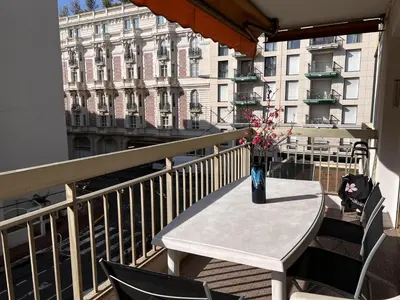 a table on a balcony with a vase of flowers at One bedroom apartment in the center of Cannes, next to the Carlton, a few meters from the Croisette - 367 in Cannes