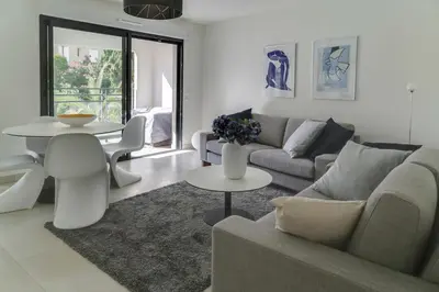 a living room with a couch and a table at IMMOGROOM- Modern - Elegant - Close to the beach -AC in Cannes