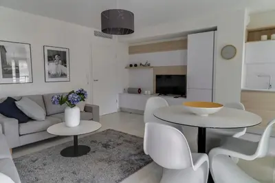 a living room with a couch and a table and chairs at IMMOGROOM- Modern - Elegant - Close to the beach -AC in Cannes