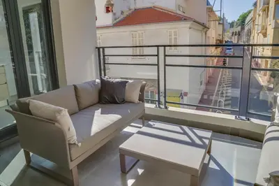 a couch on a balcony with a view of a city at IMMOGROOM- Modern - Elegant - Close to the beach -AC in Cannes