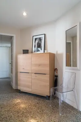 a dresser in a room with a mirror and a chair at Spacious one bedroom - great location! in Cannes