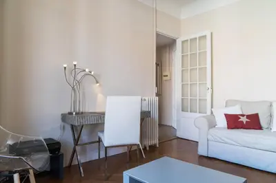 a living room with a white couch and a table at Spacious one bedroom - great location! in Cannes