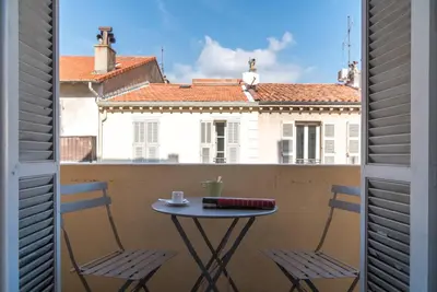 a table and chairs on a balcony with a view of a building at Spacious one bedroom - great location! in Cannes