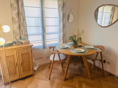 a dining room table with two chairs and a mirror at Lovely one bedroom apartment with balcony & wifi just minutes walk from Palais and Cannes beaches 109 in Cannes