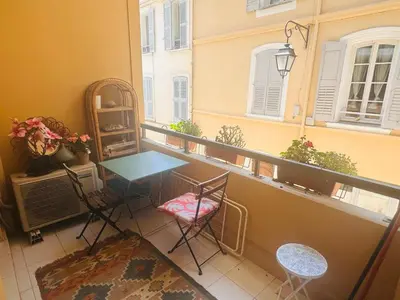 a balcony with a table and chairs and a window at Lovely one bedroom apartment with balcony & wifi just minutes walk from Palais and Cannes beaches 109 in Cannes