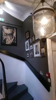 a staircase with a chandelier and pictures on the wall at Chanteclair in Cannes