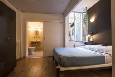 a bedroom with a bed and a bathroom with a sink at Chanteclair in Cannes