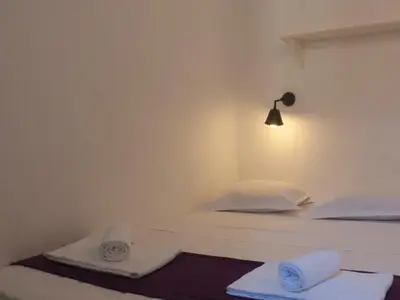 two beds in a room with a lamp and towels at Chanteclair in Cannes