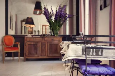 a dining room with a table and chairs and a vase of flowers at Chanteclair in Cannes
