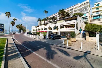 a street in front of a building with palm trees at 3 pièces- Vieux port- Terrasse - Parking Possible in Cannes