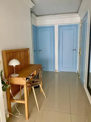a dining room with a wooden table and two blue doors at 3 pièces- Vieux port- Terrasse - Parking Possible in Cannes