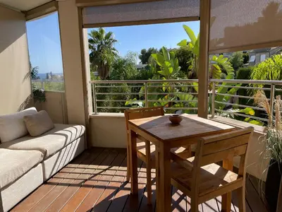 a living room with a couch and a table on a balcony at Cannes Villa St Barth in Cannes