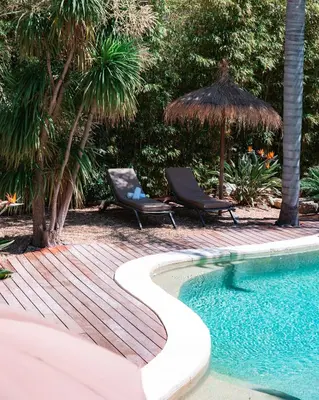 a swimming pool with two chairs and a straw umbrella at Cannes Villa St Barth in Cannes