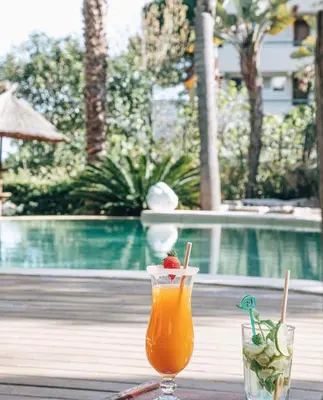 a drink sitting on a table next to a pool at Cannes Villa St Barth in Cannes