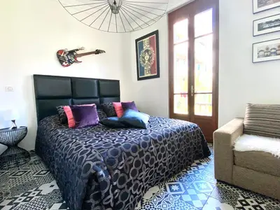 a bedroom with a bed with a guitar on the wall at #StudioCosy @ Center Cannes in Cannes