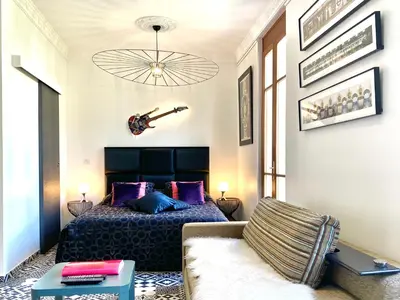 a bedroom with a bed and a guitar on the wall at #StudioCosy @ Center Cannes in Cannes