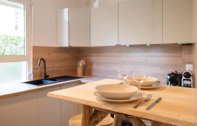 a kitchen with a wooden table with two wine glasses at Place to beach - Bord de mer Croisette in Cannes
