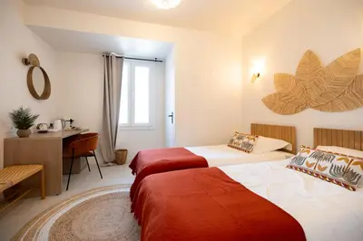 two beds in a room with a desk and a table at Place to beach - Bord de mer Croisette in Cannes