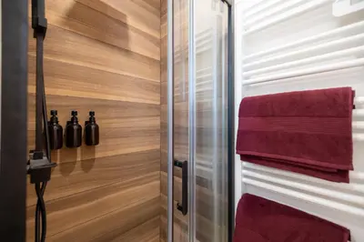 a bathroom with wood paneling and red towels at Place to beach - Bord de mer Croisette in Cannes