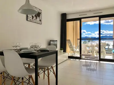 a dining room with a black table and white chairs at Cannes vue mer in Cannes