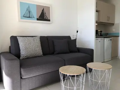 a living room with a couch and two tables at Cannes vue mer in Cannes
