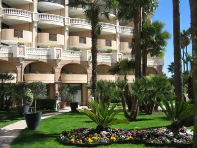 a building with palm trees and flowers in front of it at Cannes vue mer in Cannes
