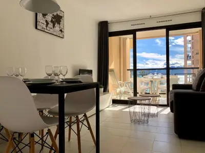 a dining room with a table and chairs and a balcony at Cannes vue mer in Cannes