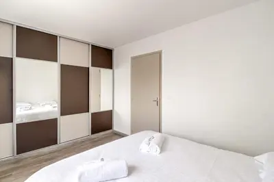 a bedroom with a white bed and a mirror at IMMOGROOM- Renovated - Wifi - Close to everything in Cannes
