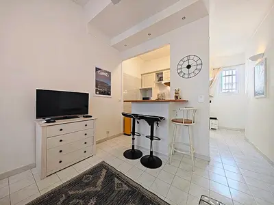 a living room with a television and a counter at Viva Riviera - 19 rue des Frères Pradignac in Cannes