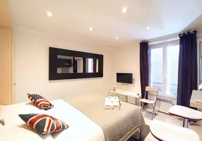a bedroom with a bed and a desk and a television at Viva Riviera - 19 rue des Frères Pradignac in Cannes
