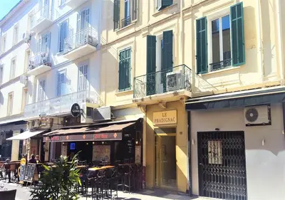 a building with tables and chairs on a street at Viva Riviera - 19 rue des Frères Pradignac in Cannes