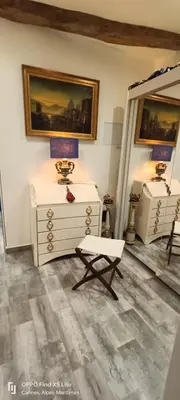a room with a dresser and a lamp and a chair at La Petit Maison du Bonheur in Cannes