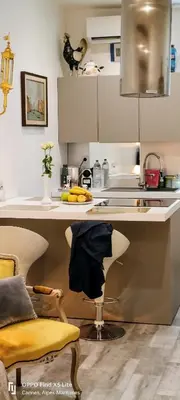 a kitchen with a sink and a counter with a chair at La Petit Maison du Bonheur in Cannes