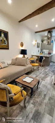 a living room with a bed and a table and chairs at La Petit Maison du Bonheur in Cannes
