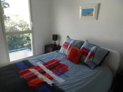 a bed with colorful pillows on it in a bedroom at Modern one bedroomed apartment just off the Cannes Seafront with a terrace and pool access 1753 in Cannes